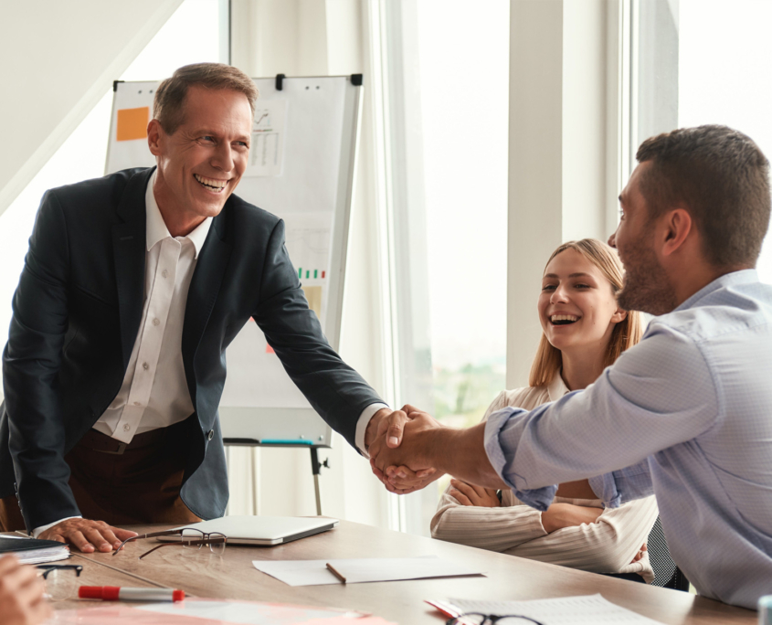 A group of professionals discussing business matters while seated around a table in an office setting