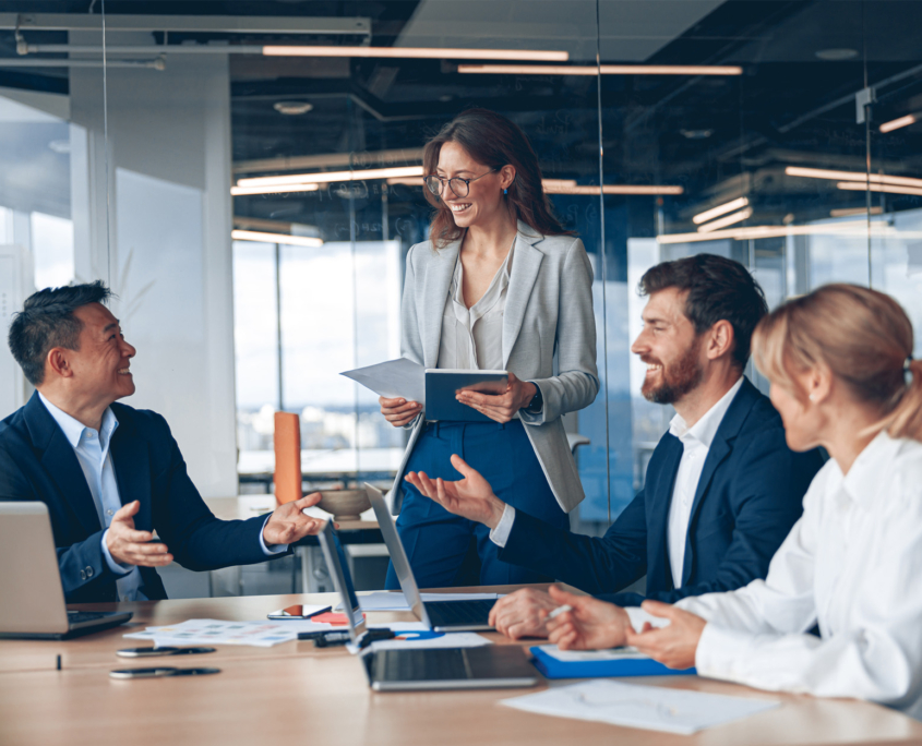 men and women in formal business attire engaged in conversation.
